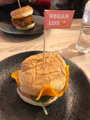 Burger with vegan cheese, fried patty, pickles, lettuce and tomato at Chillin' Cafe in Madrid