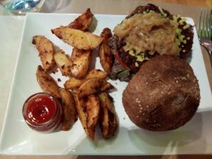 Hamburguesa vegetal -sin mucho sabor- con pan sin gluten un poco seco y queso vegano que eran unas virutas at Ecobar in Alcobendas