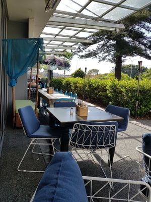 Outdoor seating adjacent to the park at The Cardamom Pod in Broadbeach