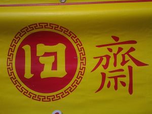 Red and yellow sign for vegan food all over thailand at Ban Khrua Jai in Trat