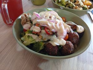 Base de quinoa, albóndigas vegan, orellanas apanadas, brócoli, tomate cherry, cilantro, cebolla roja, garbanzos crocantes con salsa de hummus y bebida de té chai. at Pot in Bogota