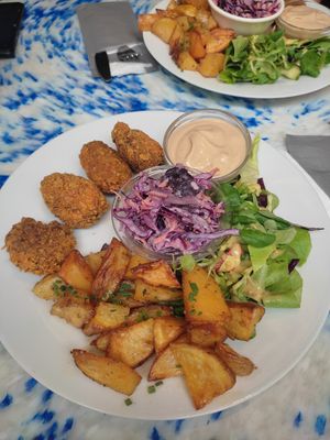 Homemade seitan "chicken" nugets in crispy spiced breadcrumbs, baked potatoes, coleslaw, bbq mayonaise and salad at Die Küche in Brno