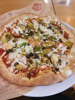 Vegan cheese, artichokes, olives, green peppers, garlic, tomatoes and brussels sprouts at Mod Pizza in London