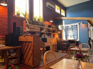Interior dining area with piano and bookshelves at Rock Hill Bakehouse Cafe in Glens Falls