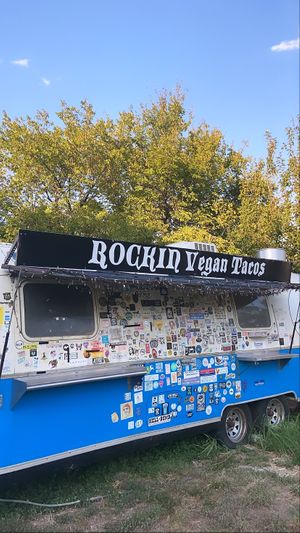 Fun stickered out van behind the truck ! at The Vegan Nom - E Cesar Chavez  in Austin