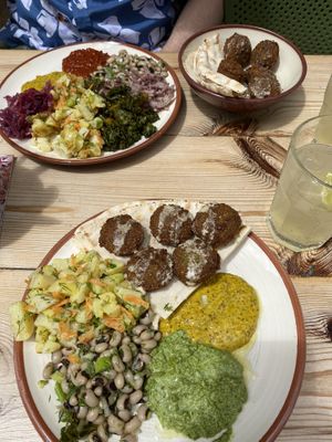 Falafel plates with assorted toppings - potato salad, black eyed beans, kale, pickled onions, red onions, harissa sauce, mustard, spinach pesto  at The Chickpea in Crete