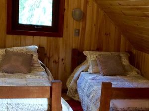 Las Bosques / the brown room.  Two twin bends and a trundle bed which sleeps two more people.  Full private bath. at Refugio Lodge in Futaleufu