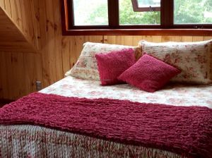 Las Rosas / the red room.  Queen bed and a trundle bed which sleeps two more people.  Full private bath. at Refugio Lodge in Futaleufu