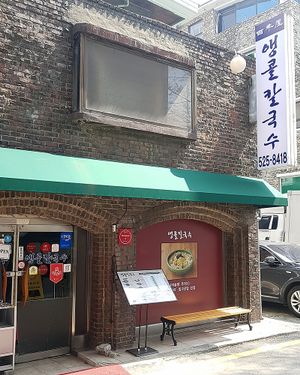 Branch building "Aengkol Kalguksu" (앵콜칼국수) specializing in noodle dishes. 
Entrance to restaurant, street view. at Baengnyeonok - 백년옥 in Seoul