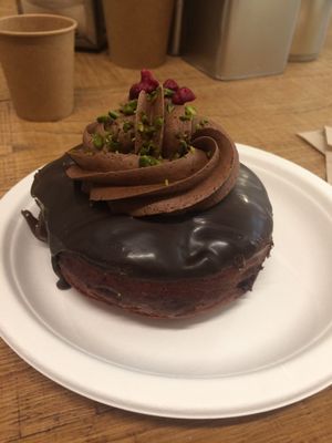 Vegan raspberry “Nutella” doughnuts with chocolate mousse on top, garnished with raspberry bits and crushed pistachios.  at Chök in Barcelona