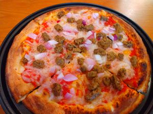 Small pizza with dairy-free cheese, plant-based sausage, red onion, and red sauce. at BRK Pizza in Naples