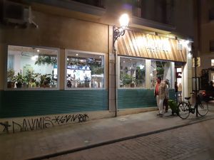 Exterior at night with two people walking by at Khambú Quart in Valencia