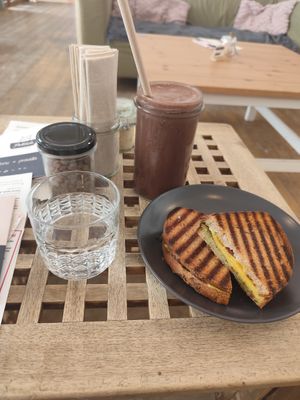 Vegan pesto, dried tomato, cheese sandwich, and banana-chocolate oat milkshake at Pelíšek in Brno