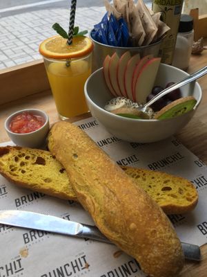 Combo vegano desayuno: pan de cúrcuma con tomate y aceite, zumo, fruta y café con leche de soja at Brunchit in Malaga