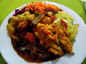 Vegetable puree (right), black beans with seitan (left), soy and chestnuts curry (top left), tofu with mushrooms and eggplant (center), assorted salads (top) at Lisbon Vegan Restaurante in Lisbon