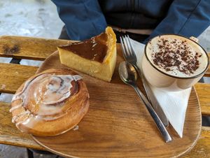 Cinnamon roll (bottom), Flan (top left), Cappuccino with oat milk (right) at VG Pâtisserie in Paris