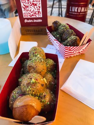 Vegan praline chocolate filling topped with peanut butter and pistachios at the front. Vegan cherry filling with bitter chocolate topping and pistachios at the back! at Lukumades in Athens
