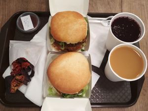 Two Dupla D (Double D) burgers served with fruit juice, vegetable chips, and BBQ sauce. January 2019. at Epoch Vegan Burger in Budapest