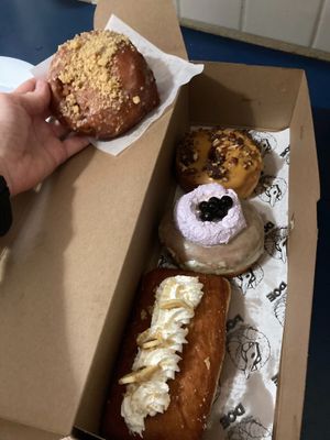 From top: Pumpkin pecan roca, taro milk tea, banana cream pie long john + fritter on the side at Doe Donuts in Portland