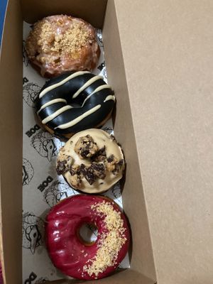 From top: bourbon apple fritter, black sesame, peanut butter cup, blackcurrant buttered toast at Doe Donuts in Portland