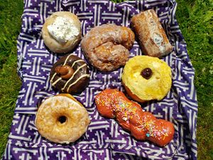 Portland fog, ube coconut fritter, blueberry buttermilk bar, pineapple upside down, fruit punch twist, salted vanilla bean, and Mississippi mud. Photo taken May 2019. at Doe Donuts in Portland