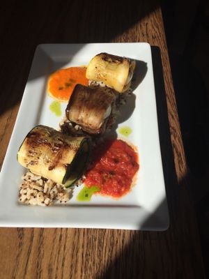 Involtini - Thinly sliced zucchini and summer squash wrapped around haloumi cheese. Served on rice & grain medley & yellow and red pepper sauces. at Mediterranea Restaurant & Bakery in Atlanta