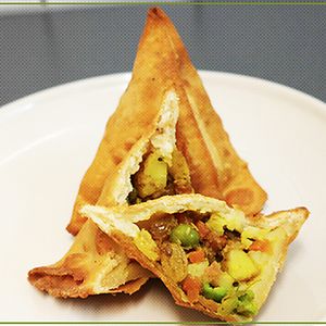 Frittierte Teigtasche gefüllt mit Kartoffeln, Erbsen, Karotten, Zwiebeln, Rosinen und ind. Gewürzen at Veggie & Vega - Restaurant in Berlin