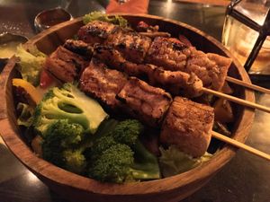 Dragon bowl with tofu, tempeh and vegan chicken skewers.  at Kismet Restaurant & Lounge in Ubud