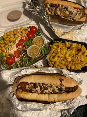 Classic & loaded Philly cheese steaks, cashew mac, and herb roasted kale Caesar salad at Farmacy Vegan Kitchen & Bakery in Tampa