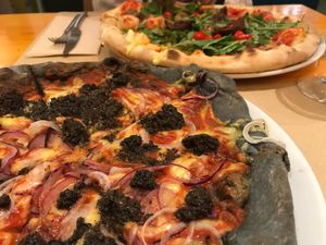 Pizza trufata con masa de carbón activo y pizza Dixie at Pizzi & Dixie in Madrid