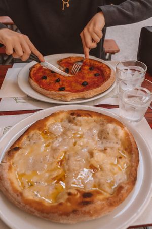 Vegan 'Four Cheese' Pizza on the near side, Marinara with Olives (our typical go-to) on the far side. at La Taverna di Pulcinella in Pisa