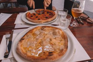Vegan 'Four Cheese' Pizza on the near side, Marinara with Olives (our typical go-to) on the far side. at La Taverna di Pulcinella in Pisa
