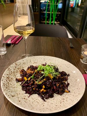 Black rice risotto and local white wine at Bistro Maha in Ljubljana