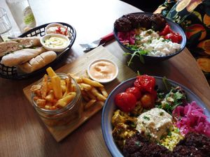 Salad bowls with bread and fries and vegan dips at Bar Cali in Nijmegen
