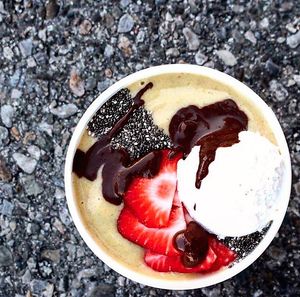 Our Mango Island Smoothie Bowl topped with chia seeds, fresh strawberries, coconut whipped cream, and our very own dark chocolate sauce!  at My Fit Little Foodie in Georgetown