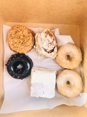 an example of a gluten friendly variety box! 2 carrot cake donuts, blueberry cake, zucchini fudge donut, a cinnamon roll, and banana oat creme pie:) at Move That Dough Baking Co. in Charlotte