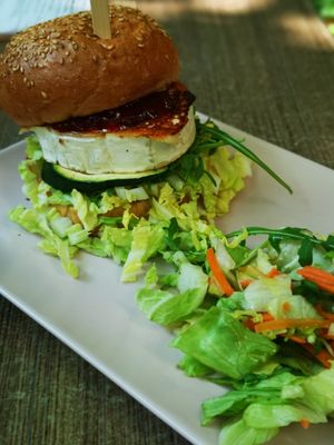 Grilled goat cheese in vegan bun with cranberry sauce and salad at Natureza in Prague