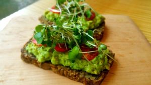 Meg's toast: House-made gf seed and nut bread topped with avocado, lemon juice, tomato, home-grown sprouts, salt and pepper. at Surya Cafe in Fitchburg