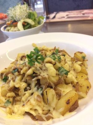Spaetzli Bonheur, golden flour and egg dumpling with potato, caramelized onions and gruyere cheese served along side a colorful blend of assorted organic greens, tomato, cucumber slices and sprouts  at Amare by Chef Chris in Mabalacat