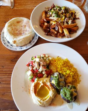 Falafel platter w/ amba, hummus, rice, pita, and Israeli salad w/ tofu feta. Also, jackfruit brisket fries w/ hummus, pickles, tomato, cucumber, tahini, amba, and harif/zhug. YES. at Aviv - Old Town in Portland