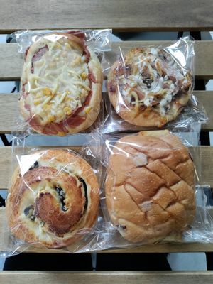 Clockwise from top left: bacon, cheese, and corn bun, cheese and ham mini pizza, lemon cake stuffed in a cherry bun, and olive, cheese, and jalapeno scroll at HiPizza in Taipei