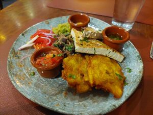 Plato centroamericano with marinated sautéed tofu and lots of black beans and rice, fried plantain and sauces at Andino Gastrobar in Malaga