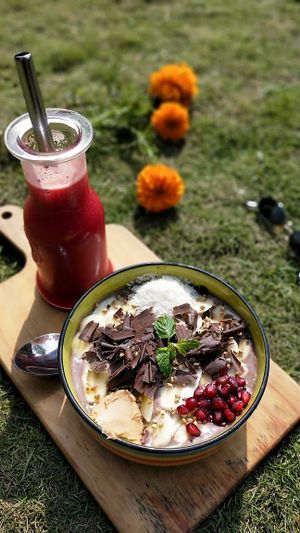 The vegan cocao PB bowl with a cold pressed Pomogrante beets juice in a sunny autum day at The Juicery Cafe in Pokhara
