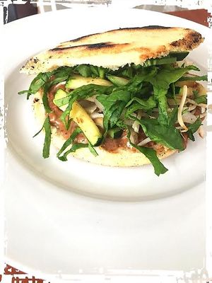 Arepa con mantequilla de cacao y mani, germinado de soya, zucchini; cebolla y espinaca. at Sat Nam in Antigua
