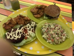 Happy cow burger with oven potatoes and guacamole salad. at Sara Green - Vegan Bistro in Bucharest