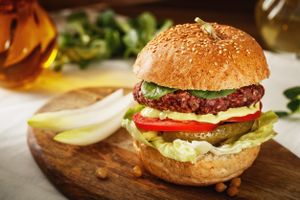 "Happy Cow" Burger -  A fluffy sourdough bun with a Beet-Chickpeas- Endives - Sesame - Patty, pickles, tomatoes,  greens and home made sauce at Sara Green - Vegan Bistro in Bucharest