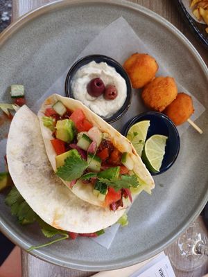 Tacos with BBQ "meat", avocado, salad, and rice cheddar croquettes at Happy Bean in Prague