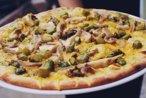 vegan pizza with cheese, basil pesto, fried oyster mushrooms with garlic and greens asparagus at Vegan Port Pizza & Restaurant in Gdansk