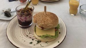 Veganer Frühstücksbürger mit „Spiegelei“ und „Bacon“, dazu Beerenkompott mit Soja-Joghurt und knusprigem Müsli, kommt mit einem Heißgetränk und Orangensaft. at Zoom Cafe in Chemnitz