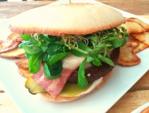 vegan burger con queso,mermelada, bacon Vegano,veganesa, pepinillos agridulces y pan tostado en horno. Acompañado de patatas fritas cortadas a mano at Masa Madre in Madrid